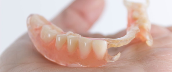 flexible nylon denture on female hand. Removable dentures flexible, devoid of nylon, hypoallergenic exempt from monomer